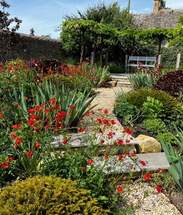 a wooden pathway ontop of a gravel garden